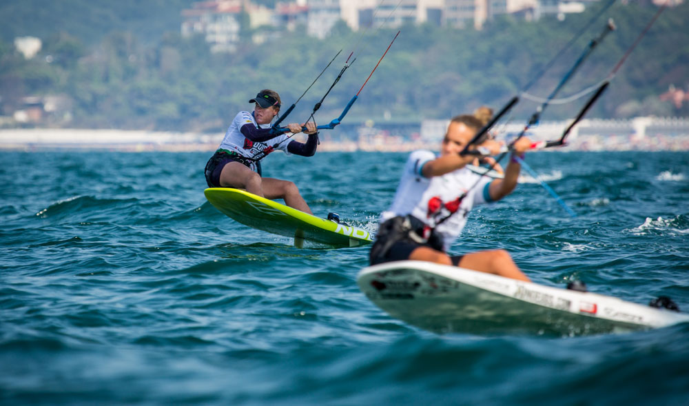 Foto di Kiters su mare francese con paese nella natura sullo sfondo